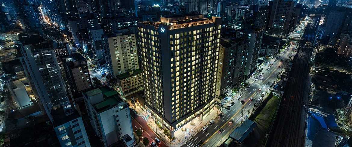 도로와 철도 옆 힐스테이트 안양펠루스 준공 건물의 야간 전경